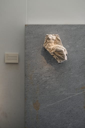 Display of an ancient marble statue of a woman