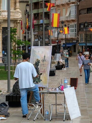 Man painting on canvas in the street