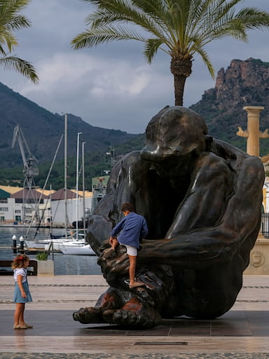 Children climbing upon a large statue