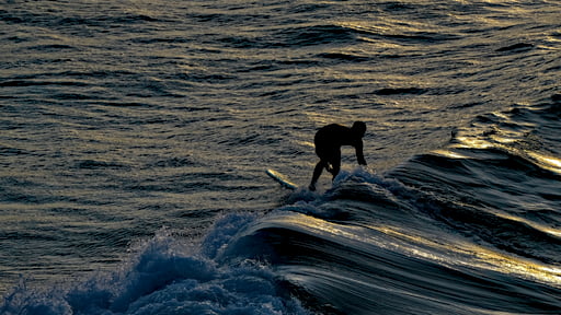 Sunset surfing over glassy waves