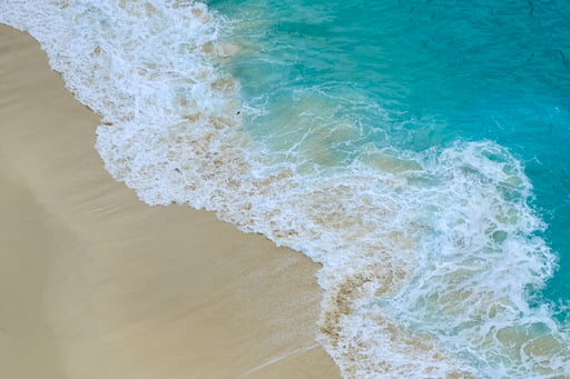 Vibrant cyan waters creeping onto shore