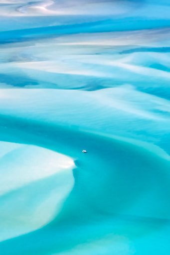 Boat traversing amidst bright white beaches and turqoise waters